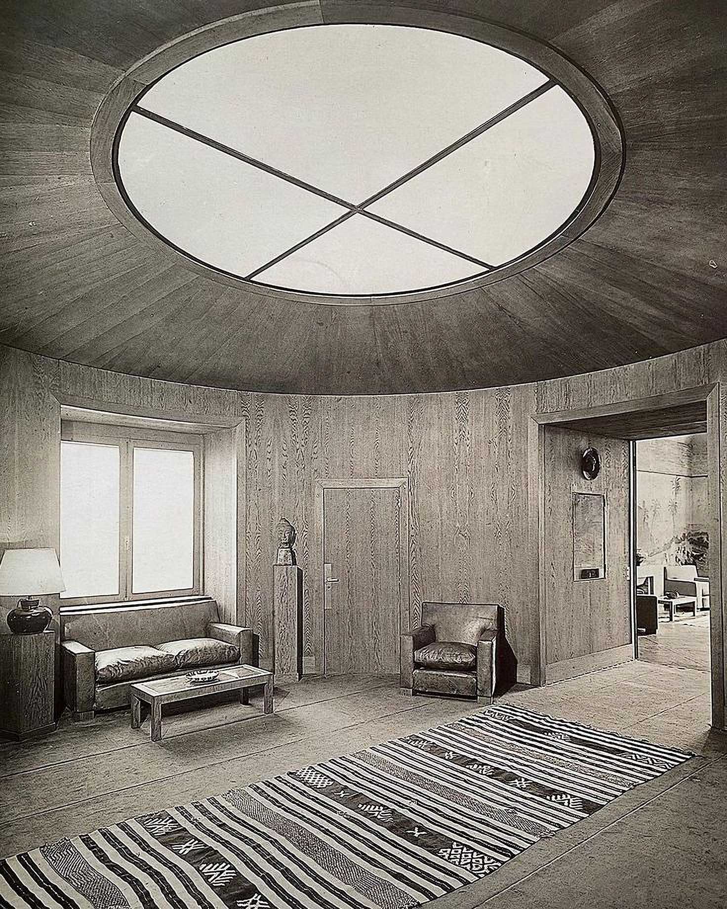 Monochrome photograph of an apartment with large circular skylight