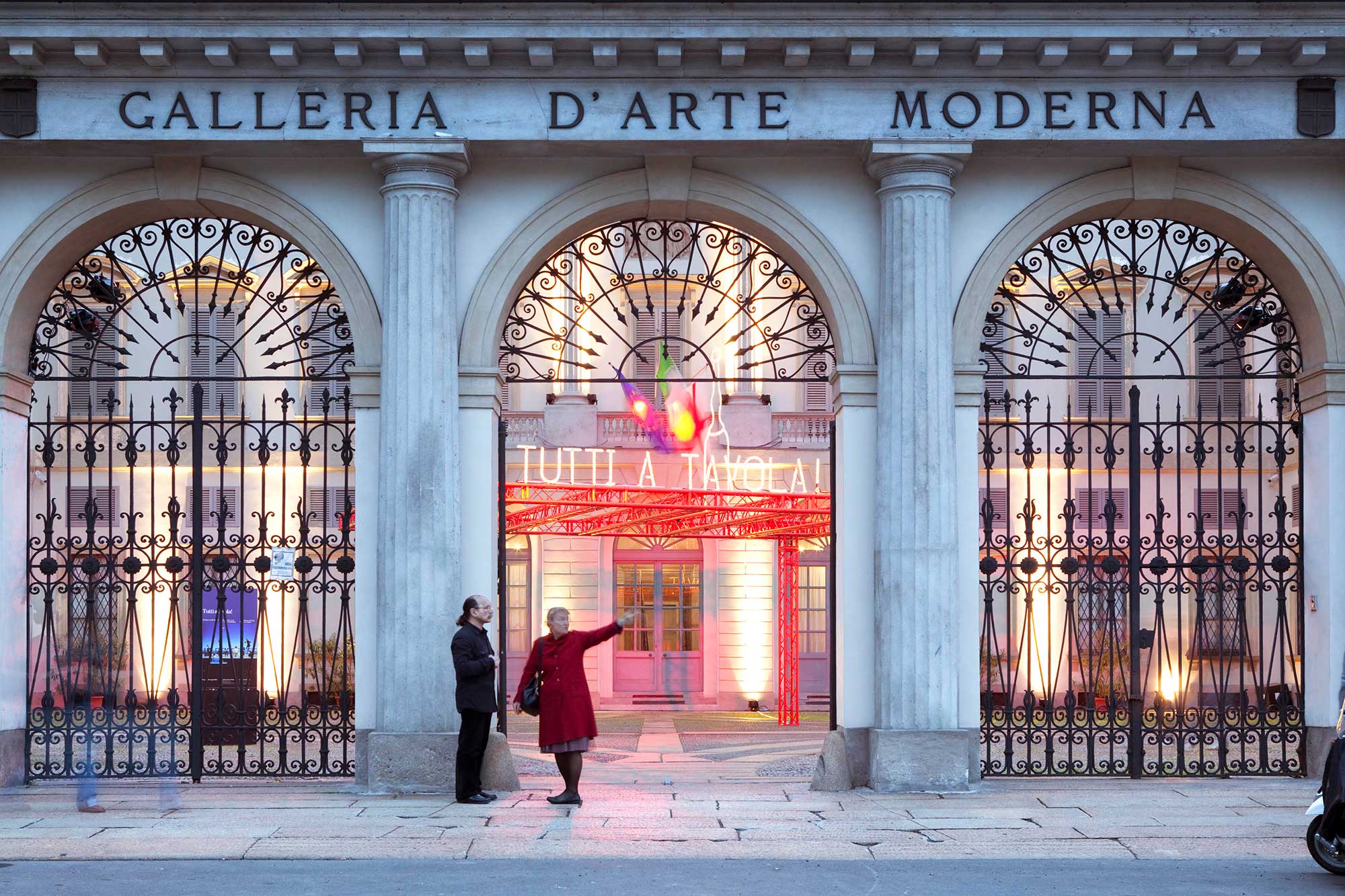 Street view of the Galleria D'Arte Moderna in Milan, with bright LED signage visible through an entranceway