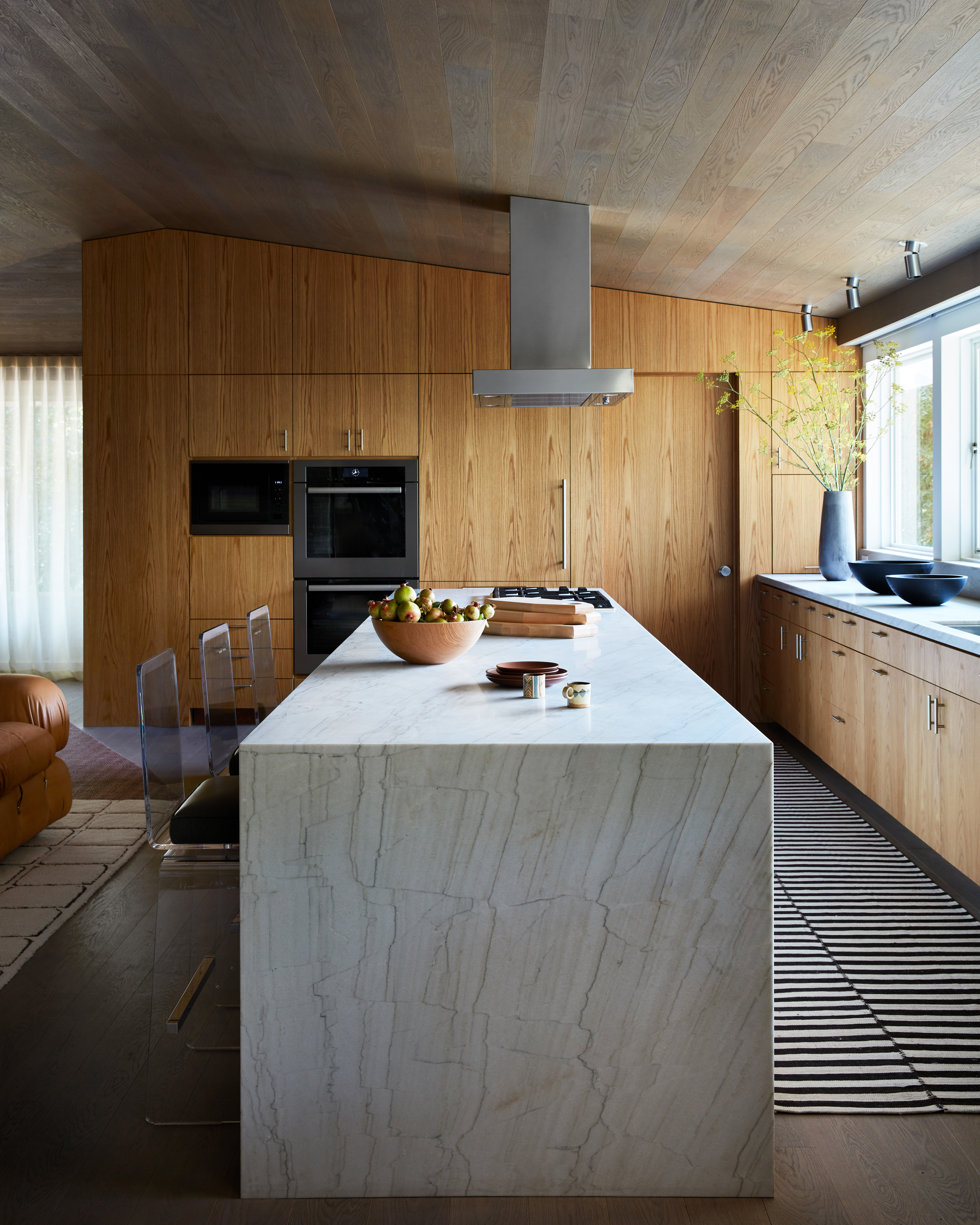 In this Chroma and Marmol Radziner collaboration, vintage 1970s Lucite and steel Waterfall stools by Charles Hollis Jones bring a playful touch to White Macaubus Quartzite in plain-sawn white oak casework, featured in Architectural Digest. Photo by Stephen Kent Johnson.