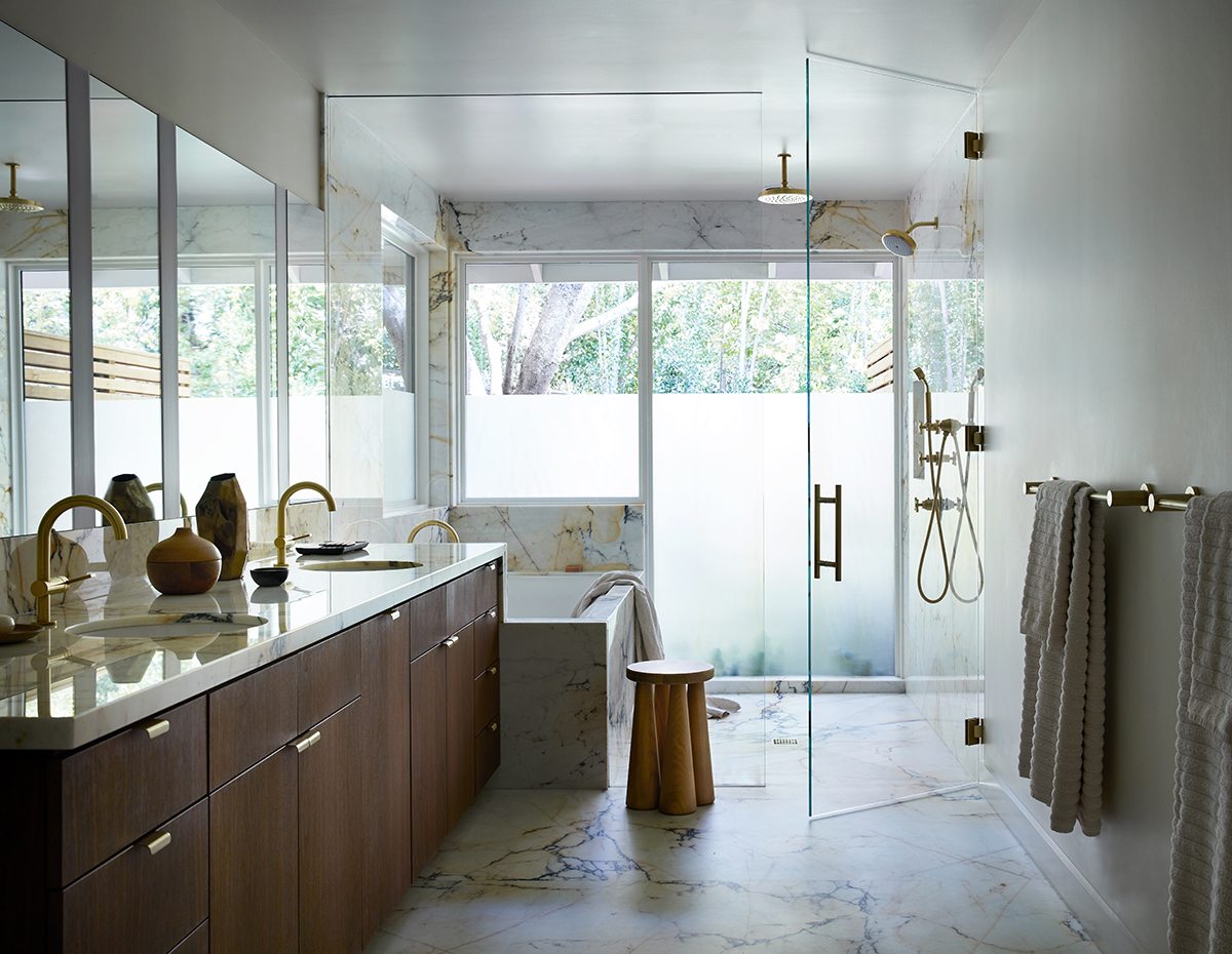 Calacatta Paonazzo stone with walnut casework and brass fixtures soothes in the primary bath. Photo by Stephen Kent Johnson.