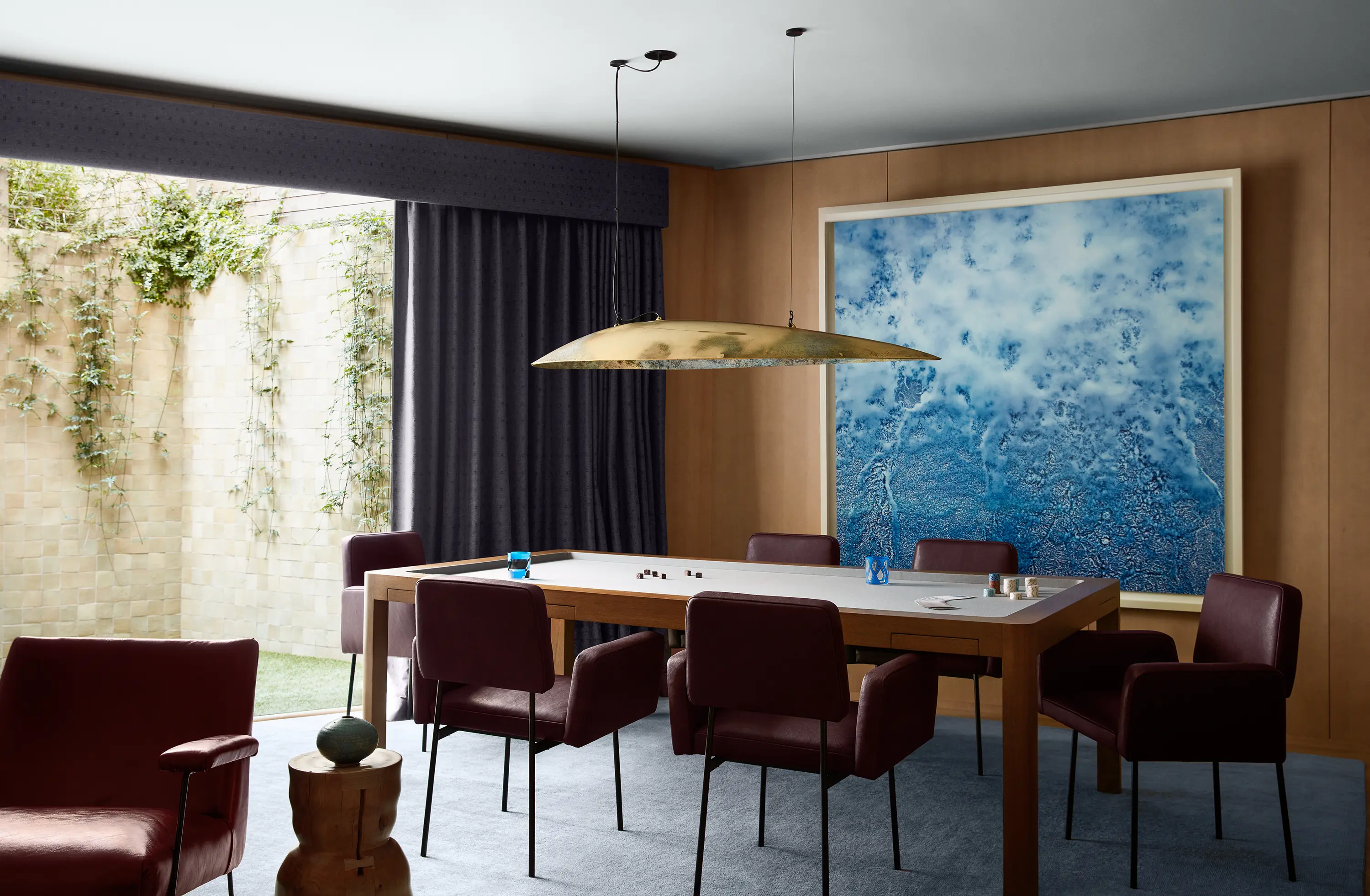 In the sportive relief of a unique Adam Fuss photogram, Dieter Vander Velpen and DIM Atelier’s Shark Light sets off a custom Chroma game table and vintage dining chairs by Nathan Lindberg in Howe leather with a view to the garden.