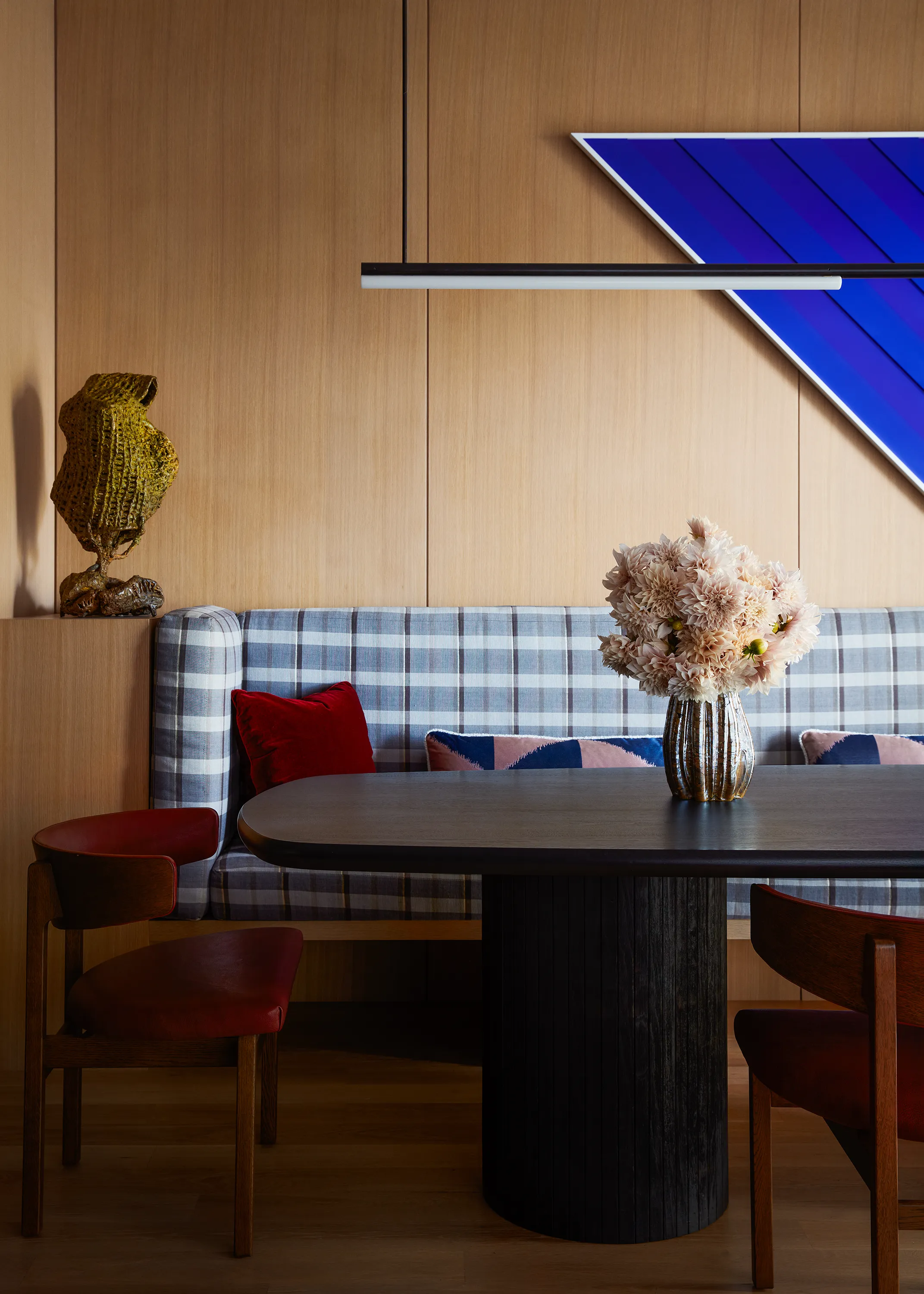 Nacho Carbonell’s sculptural bronze mesh lightwork and Sara VanDerBeek’s vibrant “Cyclades I” play against a sleek Michael Anastassiades fixture in the dining room.