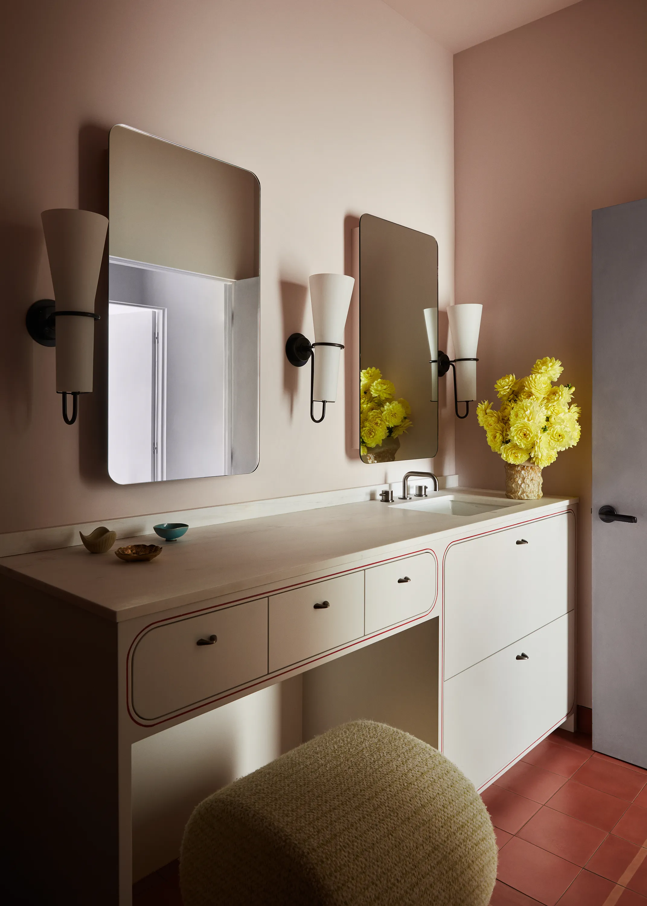 Vintage sconces by Hans-Agne Jakobsson and Saguaro Glass by The Long Confidence add playful yet elevated touches to the youthful bathroom.