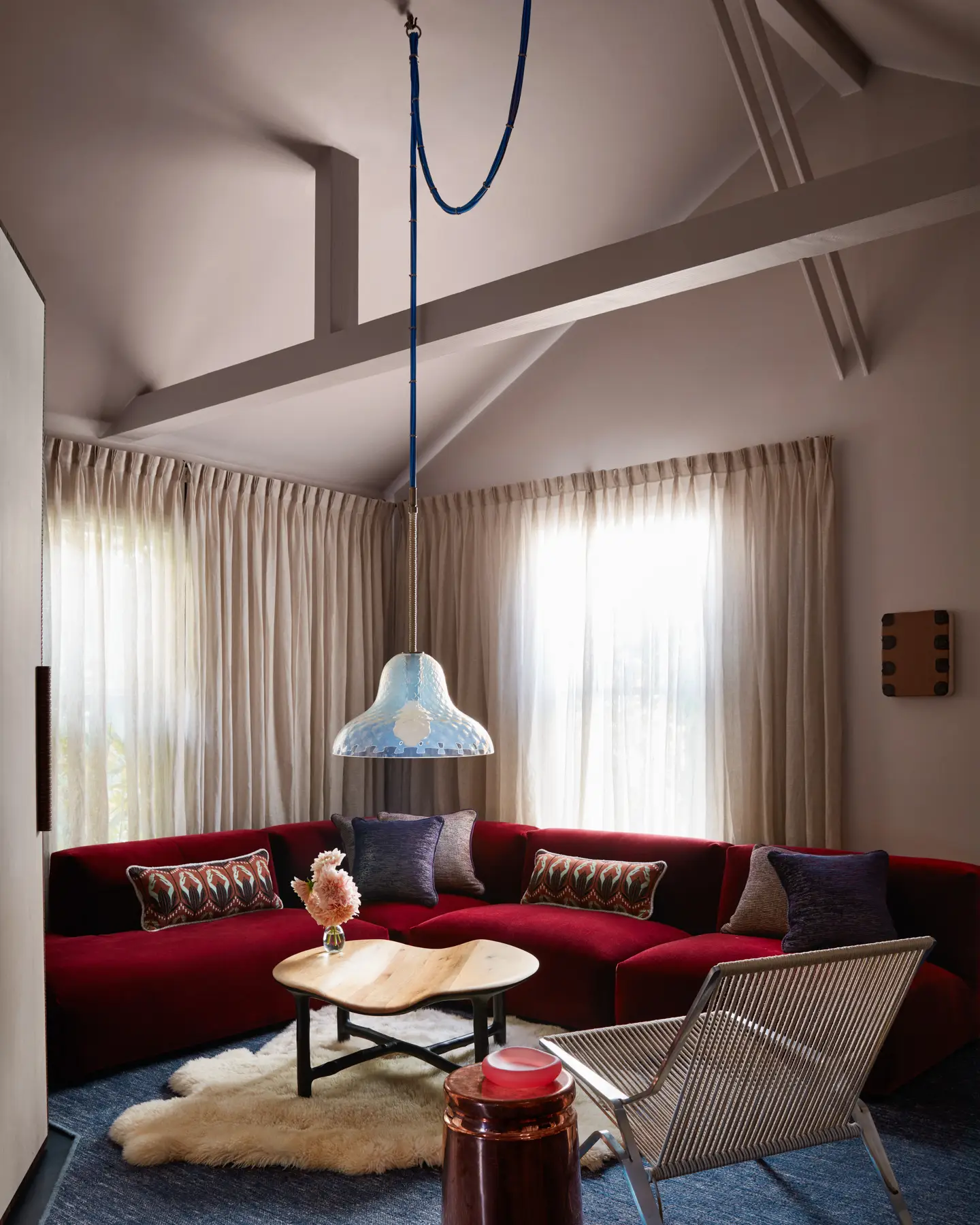 A Carlo Nason for Mazzega Murano glass pendant lamp sinks in the groove of a vintage mohair velvet sofa and PK25 Lounge Chair by Poul Kjaerholm with a Valentin Loellmann coffee table, polished copper Max Lamb stool, and work by Bret Slater.