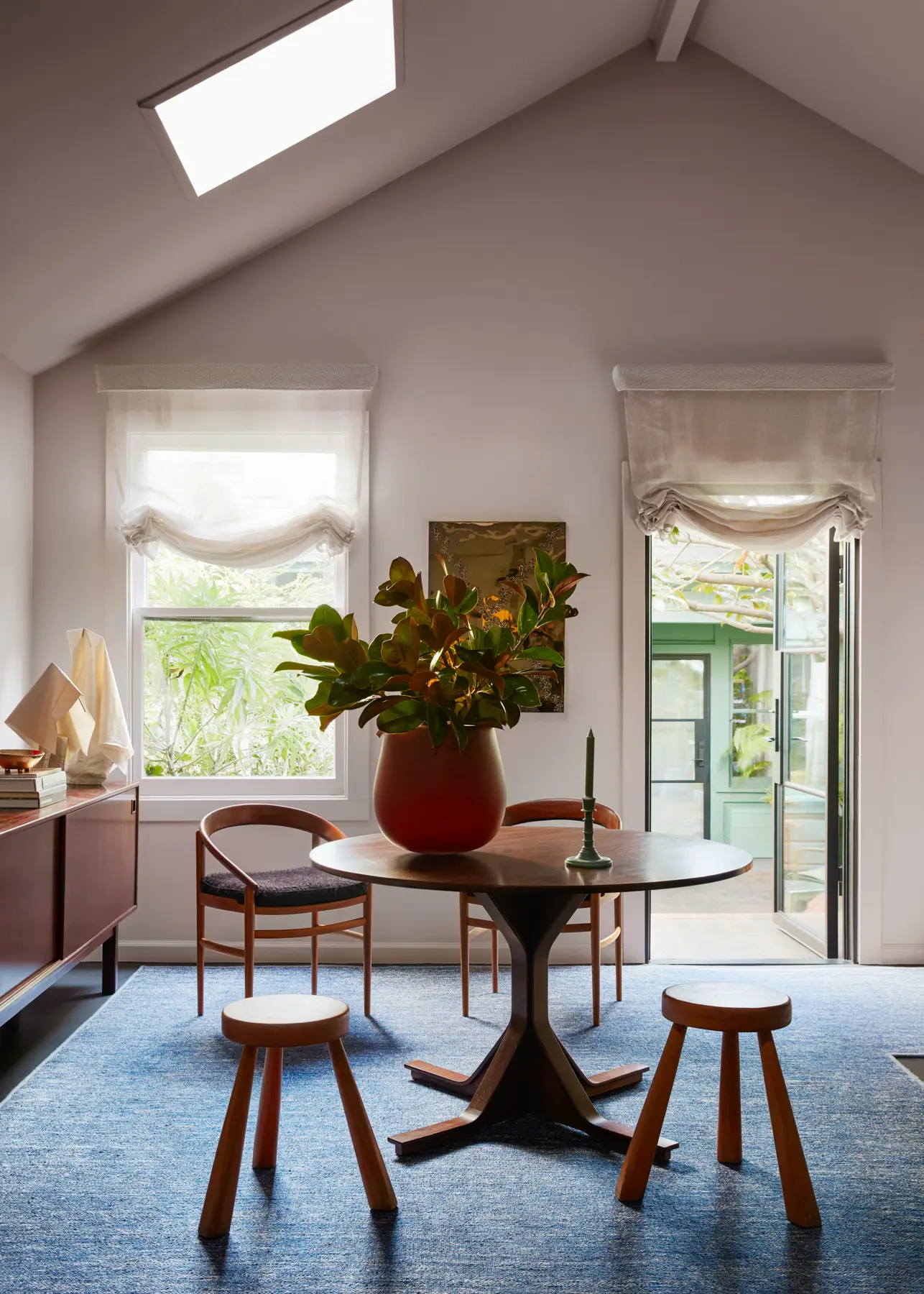 Brockmann Petersen “Model 123” dining chairs and vintage stools by Charlotte Perriand for Les Arcs connect at a Gianfranco Frattini dining table.